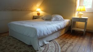 Chambre mansardée avec lit double sous les combles du Manoir de Keranflec’h à Milizac, près de Brest