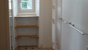 Douche à l’italienne et carrelage blanc dans une salle d’eau du Manoir de Keranflec’h